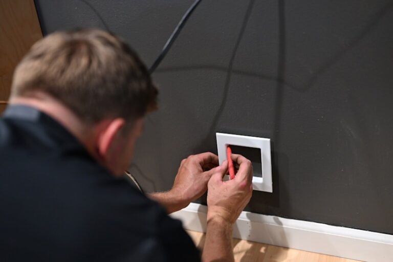 Elektrikář kontroluje elektroinstalaci ve zdi